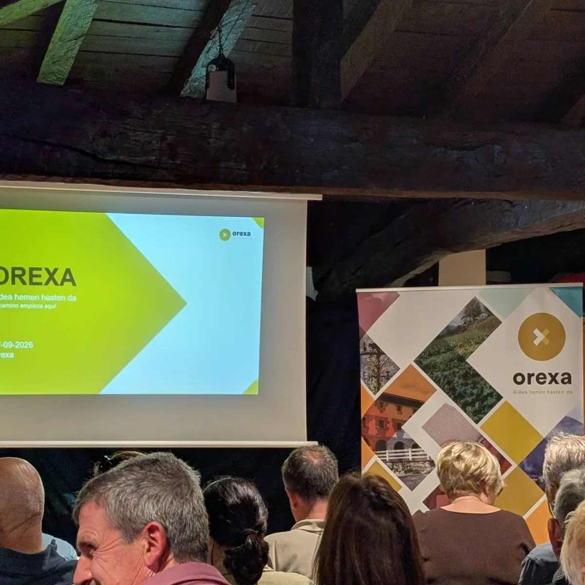 Presentación de Orexa ante los participantes en una sala con vigas de madera