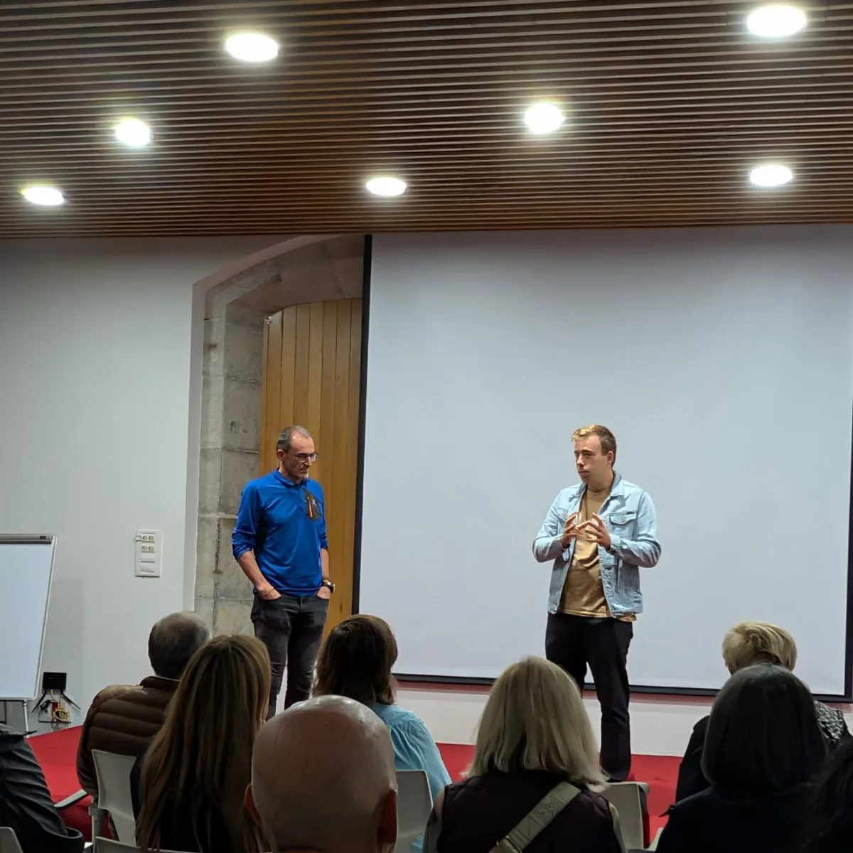Dos ponentes se dirigen al público en una sala de reuniones