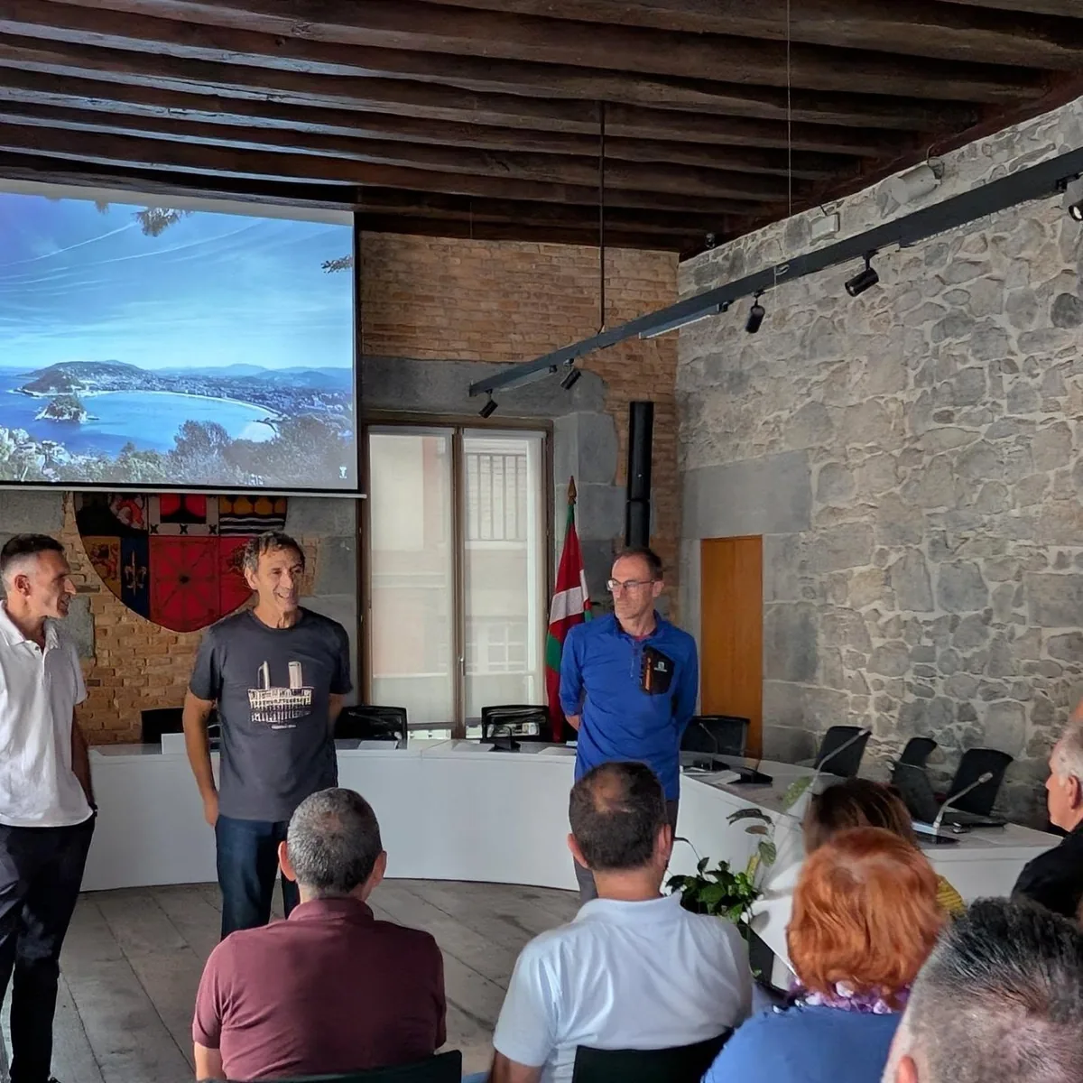 Los anfitriones reciben al grupo en una sala de piedra con una proyección en pantalla